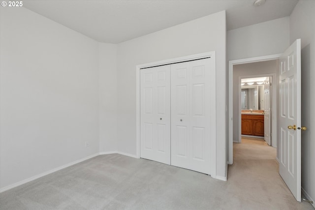 unfurnished bedroom with a closet, sink, and light carpet