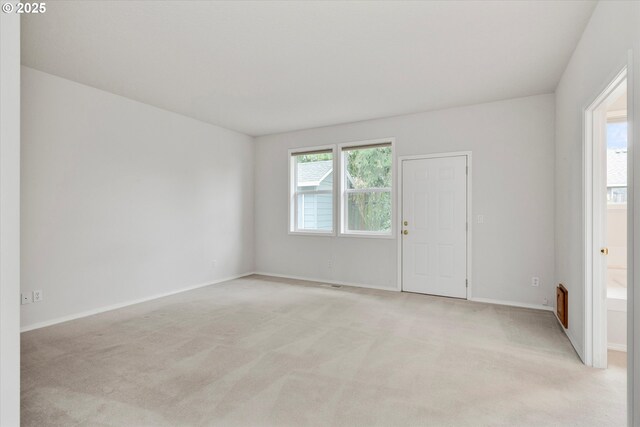 unfurnished room with light colored carpet