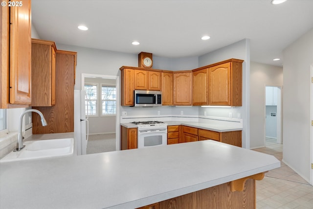 kitchen featuring sink, white appliances, and kitchen peninsula