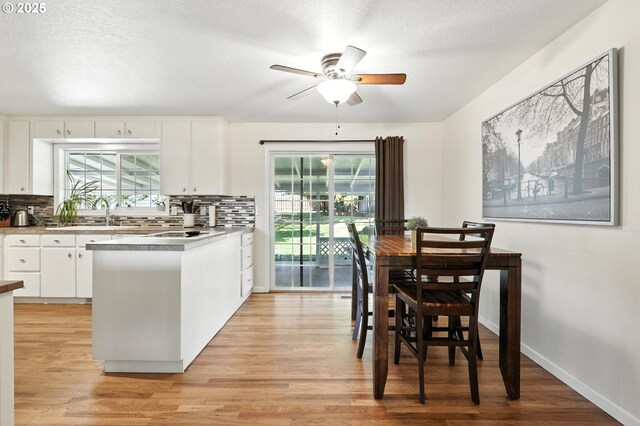 3216 Oakcrest Dr, Forest Grove, OR 97116 - kitchen featuring ceiling fan, light wood-style floors, white cabinetry, and backsplash