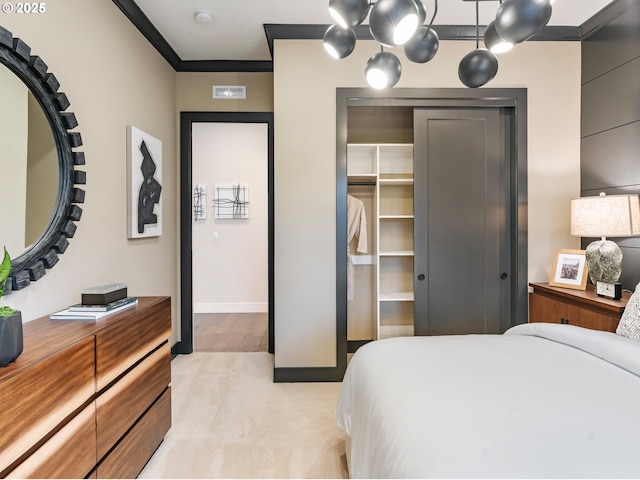 carpeted bedroom featuring crown molding and a closet