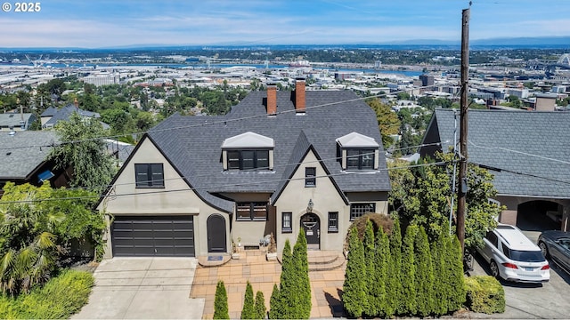 view of front of home with a garage, driveway, a shingled roof, and stucco siding