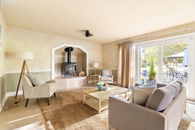 living room with a wood stove and baseboards