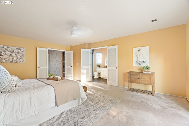 bedroom with light colored carpet, connected bathroom, and baseboards