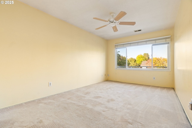 carpeted spare room with a ceiling fan