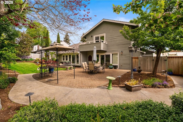rear view of property featuring a gazebo, a patio, and a balcony