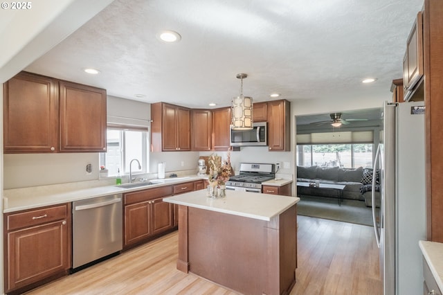 kitchen featuring a wealth of natural light, appliances with stainless steel finishes, light wood-style floors, and a sink