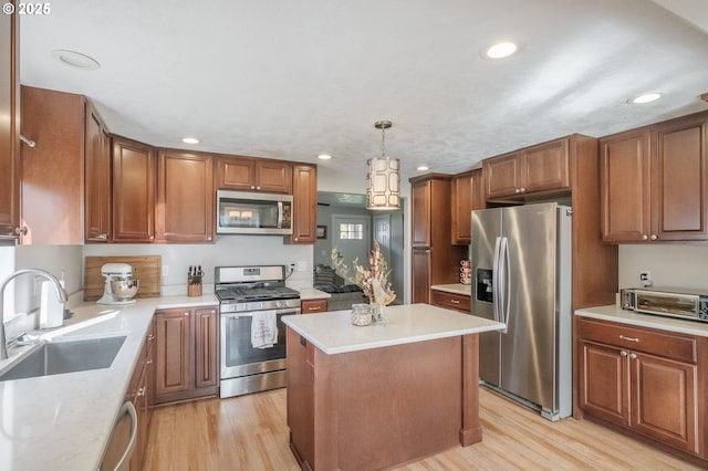 kitchen with a sink, light countertops, light wood-style flooring, and stainless steel appliances