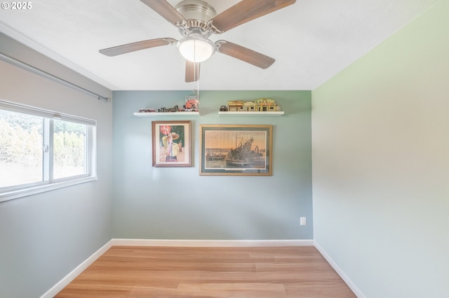 unfurnished room featuring ceiling fan, light wood-style floors, and baseboards