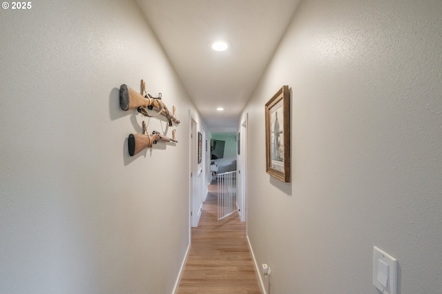 corridor featuring recessed lighting, light wood-style flooring, and baseboards