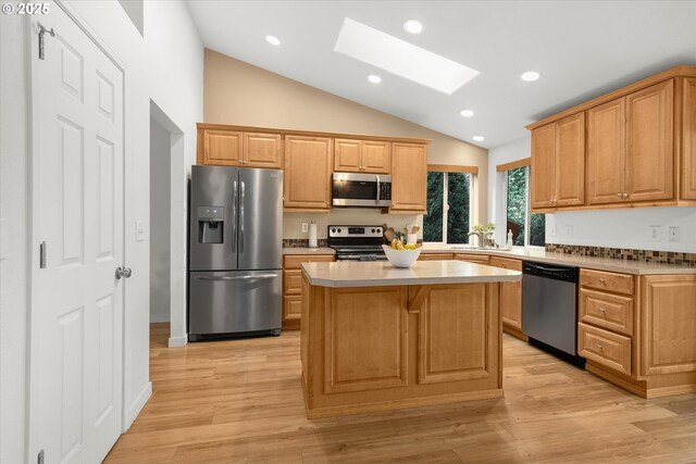 1573 SE 67th Ave, Hillsboro, OR 97123 - kitchen with appliances with stainless steel finishes, vaulted ceiling, a skylight, a center island, and light wood-type flooring