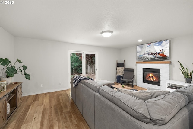 1573 SE 67th Ave, Hillsboro, OR 97123 - living room with a fireplace, light wood-style flooring, baseboards, and recessed lighting
