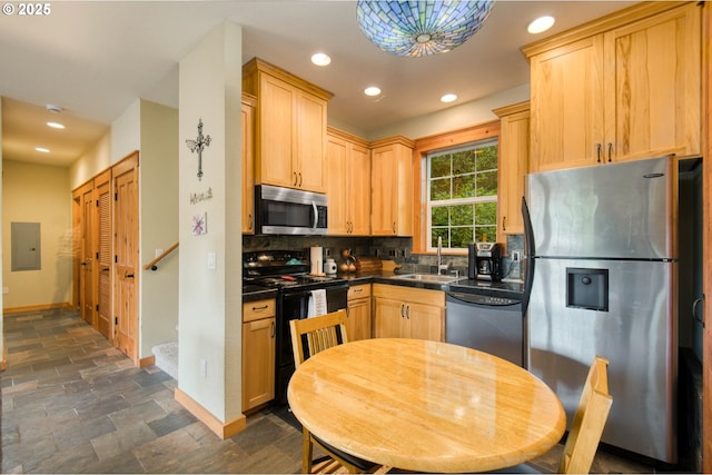 2064 NW 33rd St, Lincoln City, OR 97367 - kitchen with stainless steel appliances, a sink, dark countertops, baseboards, and dark stone finish flooring
