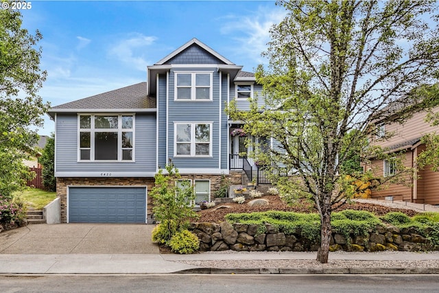 6420 SE Dunbar Dr, Portland, OR 97236 - view of front of house featuring an attached garage, concrete driveway, stone siding, and roof with shingles