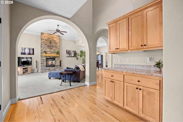 6420 SE Dunbar Dr, Portland, OR 97236 - bar with ceiling fan, light wood-style flooring, ornamental molding, a fireplace, and arched walkways