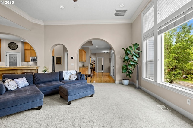 6420 SE Dunbar Dr, Portland, OR 97236 - living room featuring light colored carpet, plenty of natural light, crown molding, arched walkways, and recessed lighting
