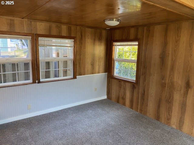 681 SE Neptune Ave, Lincoln City, OR 97367 - carpeted spare room with wood walls and wooden ceiling