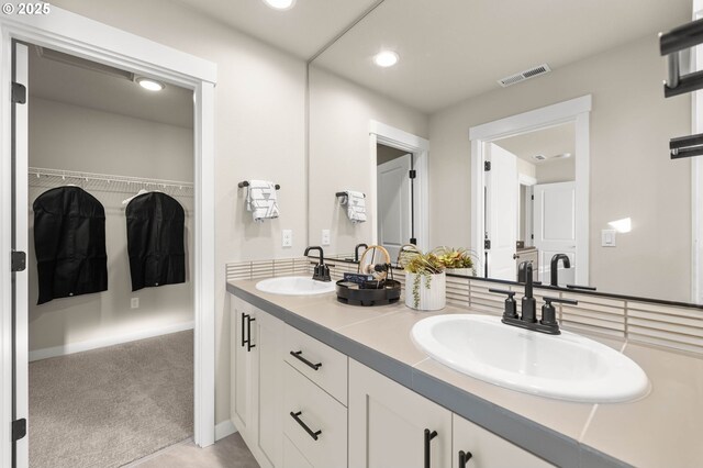 full bathroom with double vanity, a sink, visible vents, and recessed lighting