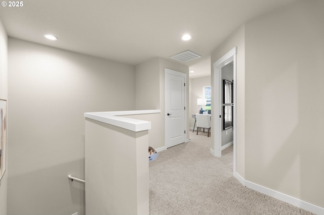 hall with recessed lighting, light carpet, visible vents, an upstairs landing, and baseboards