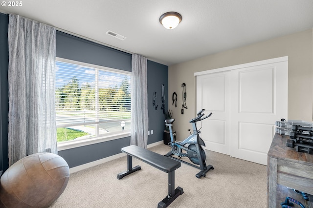 exercise room featuring carpet floors, visible vents, and baseboards