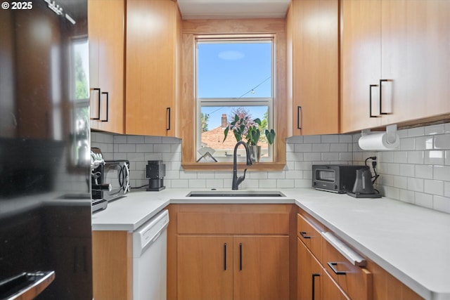2055 N Alberta St, Portland, OR 97217 - kitchen with freestanding refrigerator, a sink, white dishwasher, tasteful backsplash, and light countertops