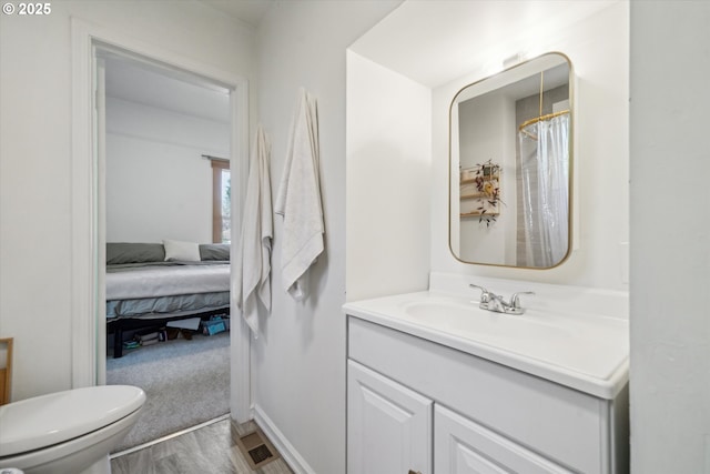 2055 N Alberta St, Portland, OR 97217 - ensuite bathroom featuring toilet, vanity, and wood finished floors