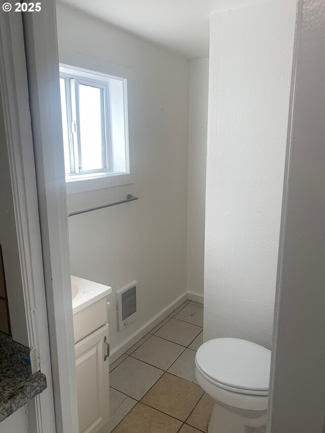 bathroom featuring visible vents, toilet, vanity, tile patterned flooring, and baseboards