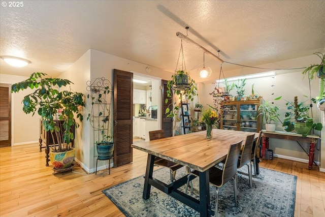 5770 SW Cranberry Ct, Beaverton, OR 97007 - dining space with a textured ceiling, light wood-style floors, and baseboards