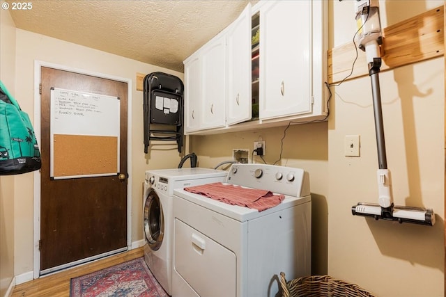 5770 SW Cranberry Ct, Beaverton, OR 97007 - laundry area with washing machine and dryer, cabinet space, light wood-style floors, and a textured ceiling