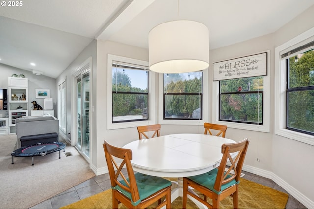 dining room with vaulted ceiling, light tile patterned floors, light colored carpet, and a healthy amount of sunlight