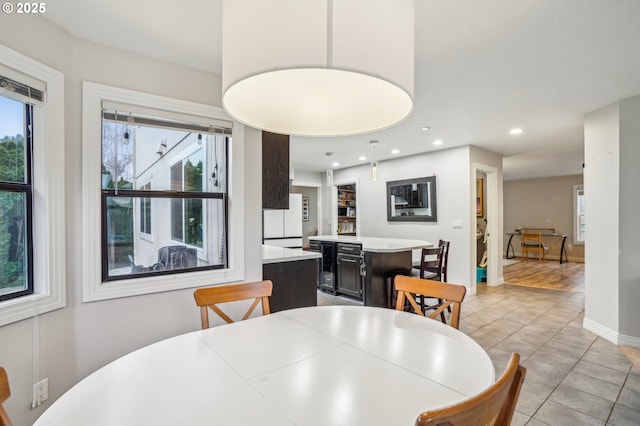 dining space featuring light tile patterned floors, baseboards, and recessed lighting