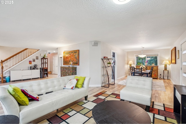 living room featuring a textured ceiling and light hardwood / wood-style floors