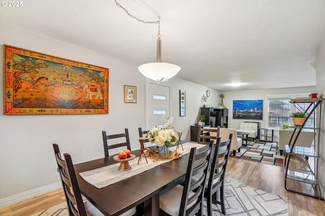 dining area with baseboards and wood finished floors