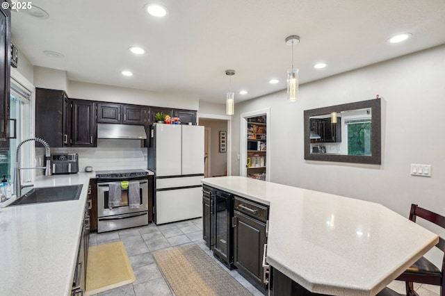 kitchen featuring pendant lighting, backsplash, white fridge, sink, and stainless steel electric stove