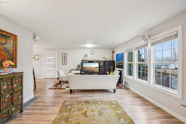 living room with light wood-type flooring and baseboards