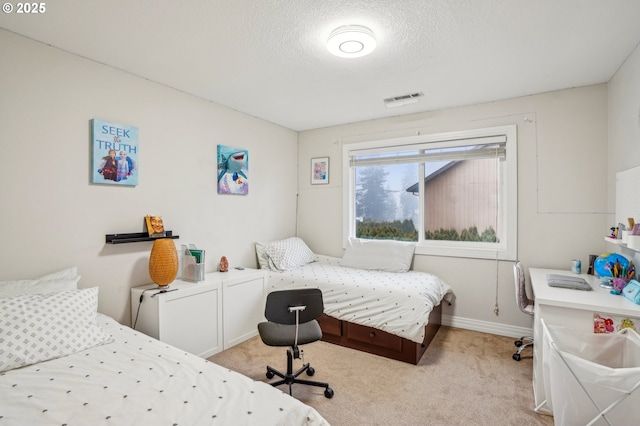 bedroom with a textured ceiling and light colored carpet