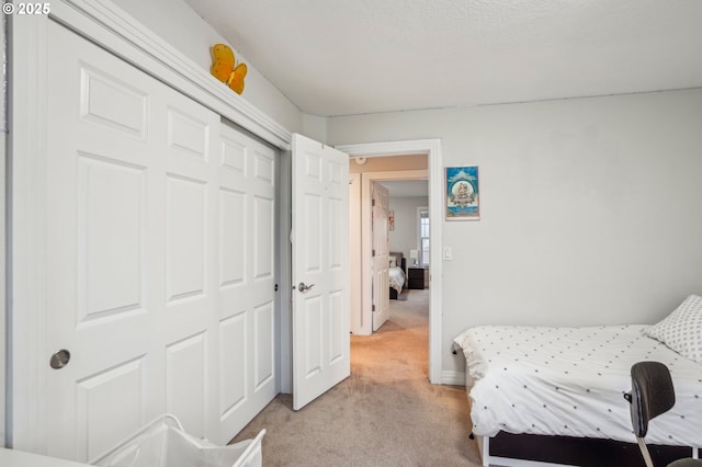 bedroom featuring a closet and light colored carpet