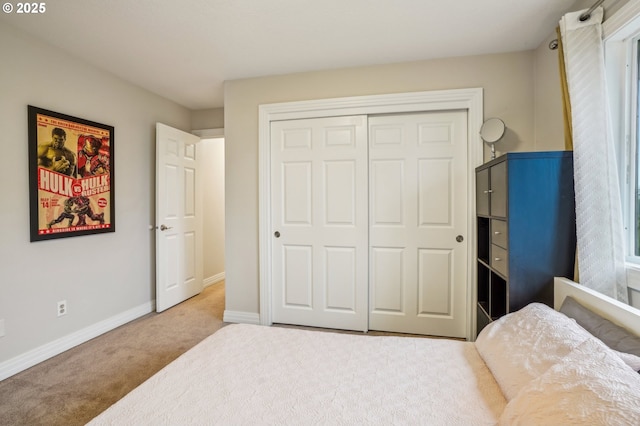 bedroom featuring a closet, light colored carpet, and baseboards