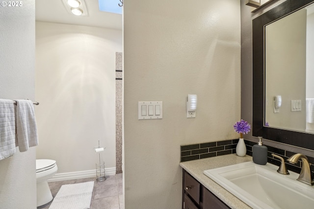 bathroom featuring toilet, baseboards, and vanity