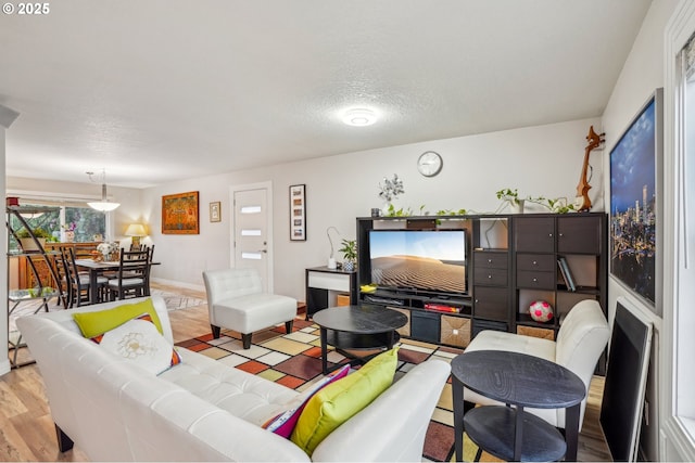 living room with light hardwood / wood-style flooring and a textured ceiling