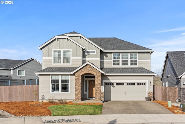 craftsman inspired home with driveway, a shingled roof, fence, and board and batten siding