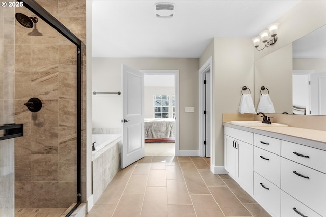 bathroom with a stall shower, tile patterned flooring, vanity, and ensuite bath