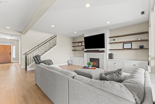 living room with light wood finished floors, stairs, visible vents, and recessed lighting