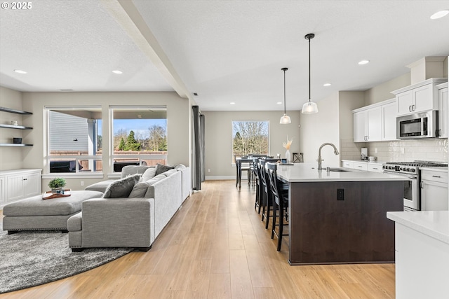 kitchen with stainless steel appliances, a kitchen breakfast bar, light wood-style floors, and decorative backsplash