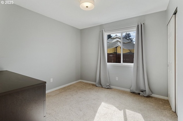 unfurnished bedroom featuring a closet, carpet flooring, and baseboards