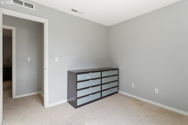 unfurnished bedroom with visible vents, carpet floors, and baseboards