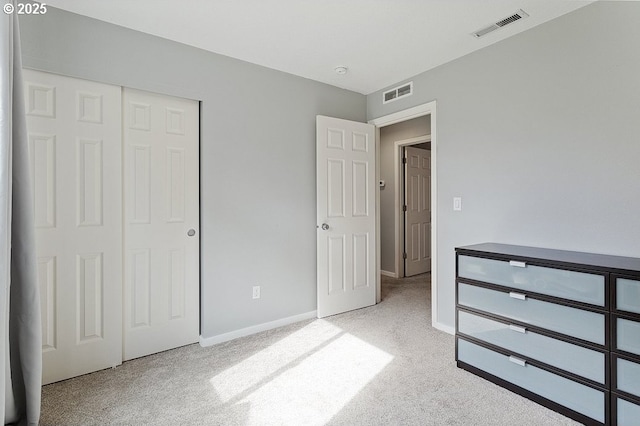 unfurnished bedroom with visible vents, baseboards, carpet, and a closet