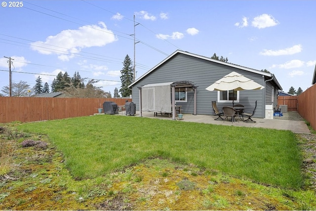 back of house featuring a patio, a yard, a fenced backyard, and central AC