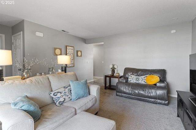 carpeted living room featuring visible vents and baseboards