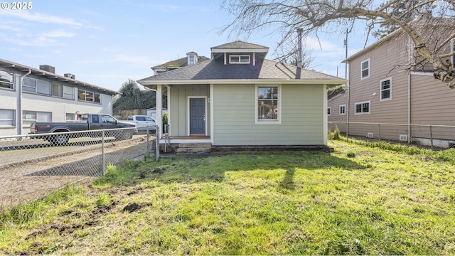 bungalow-style house featuring a shingled roof, a front yard, and fence